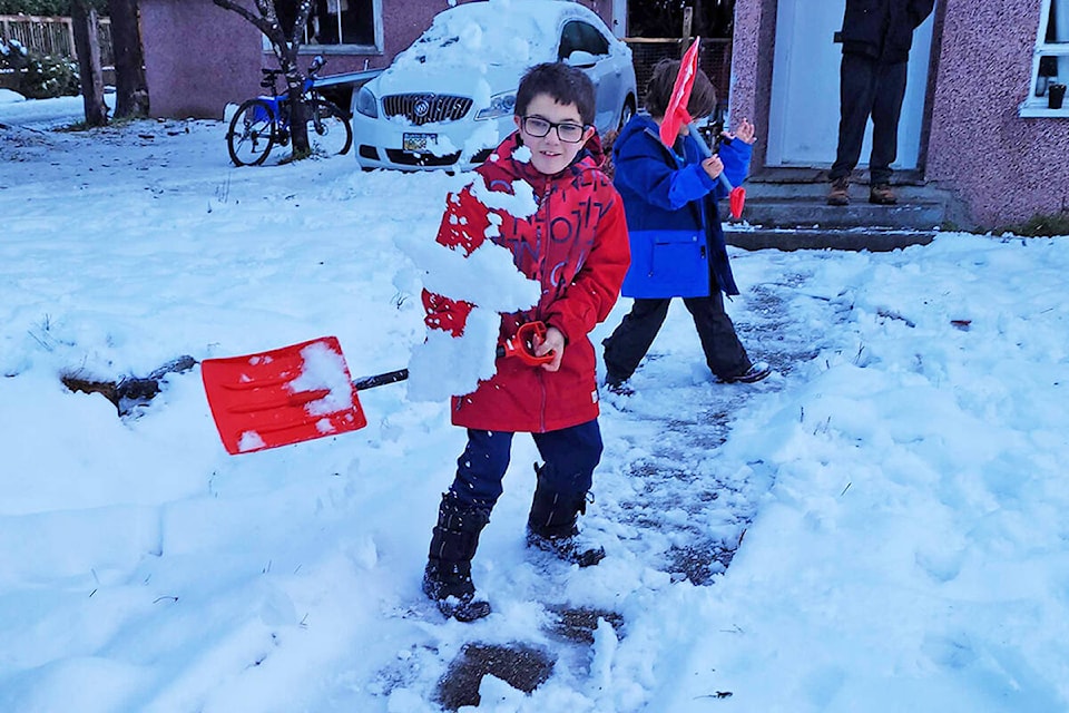 Brandon and Jax shovel their walk and play in the snow. (Neil Corbett/The News)