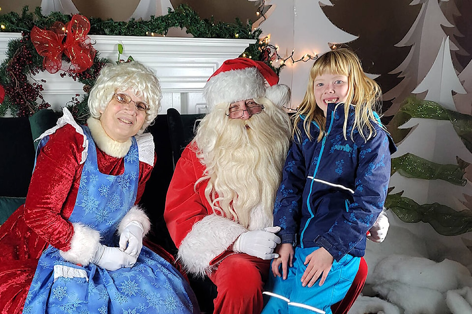 Ellen McDonald with Santa and Mrs. Claus at Pitt Meadows Christmas on Friday night. (Neil Corbett/The News)