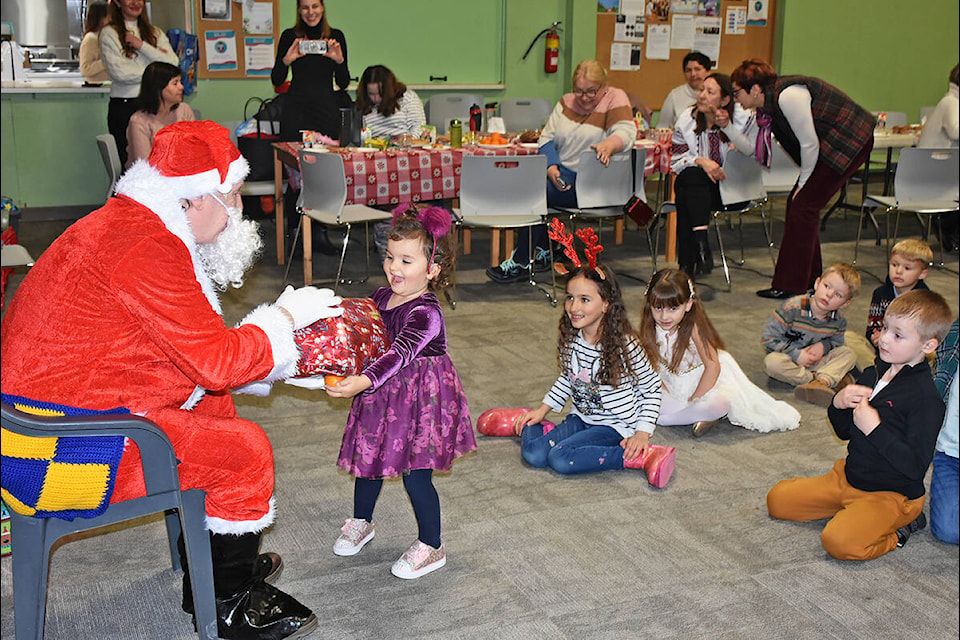 Delighted children get a present from Santa as Ukrainian newcomers to Maple Ridge hold a Christmas celebration. (Neil Corbett/The News)