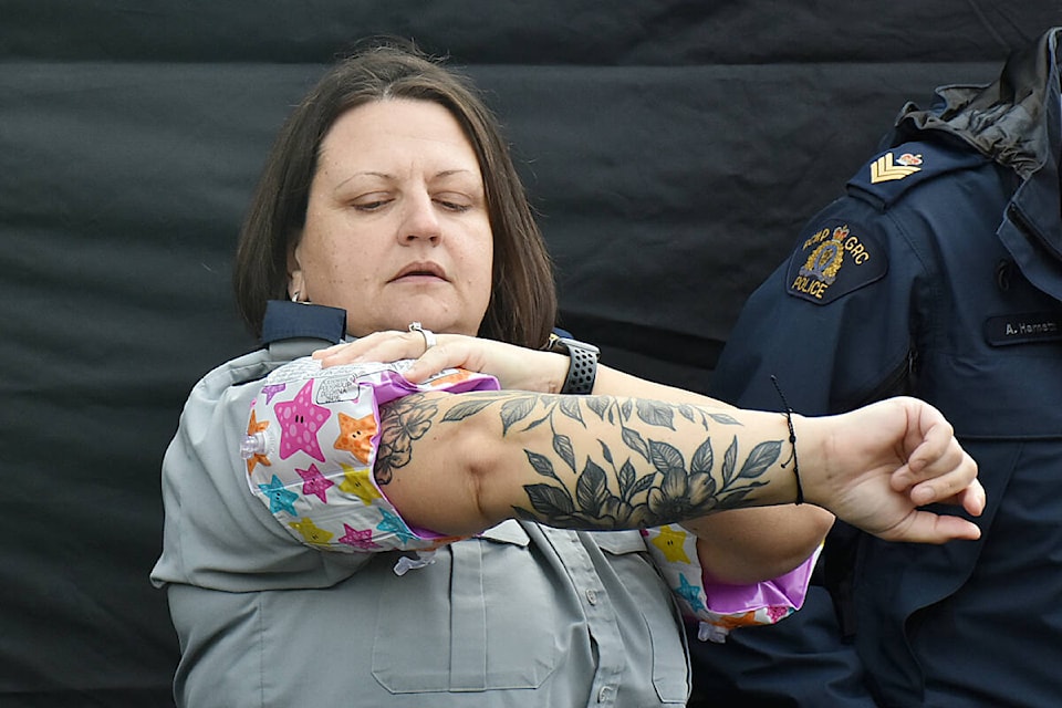 A member of the Ridge Meadows RCMP detachment readies her water wings before running into the Alouette River. (Colleen Flanagan/The News)