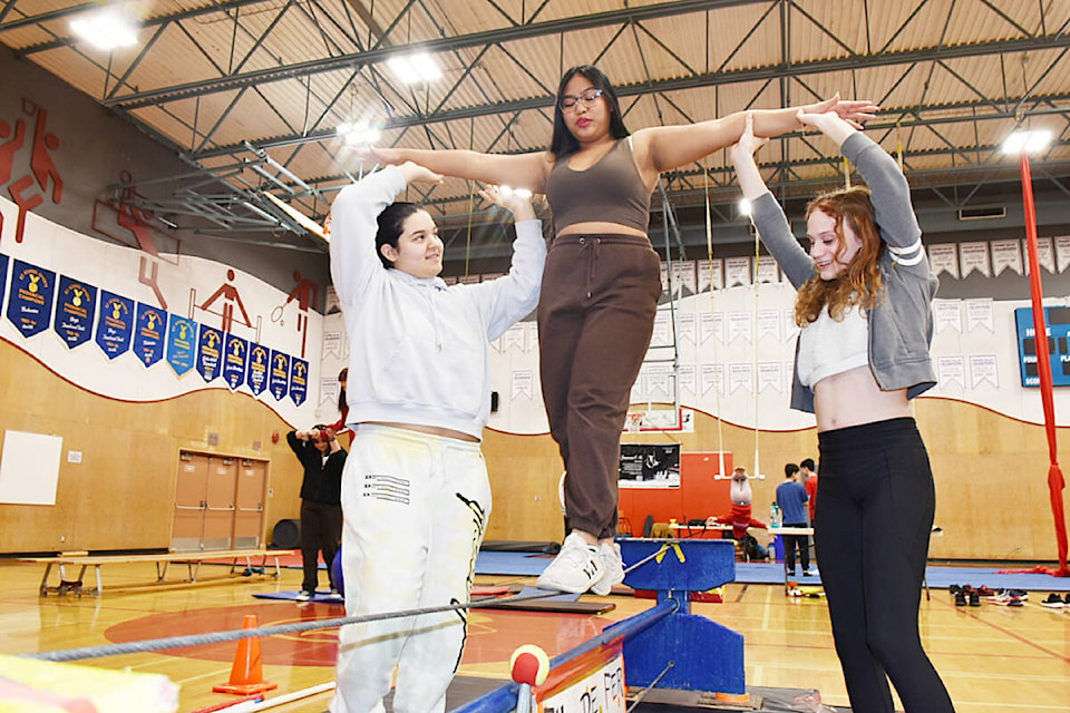 Grade 8 students Sofia Dharamshi, 14, left, and Haileigh Belich, 13, right, support Kristel Salarda, 13, on the tightrope. (Colleen Flanagan/The News)