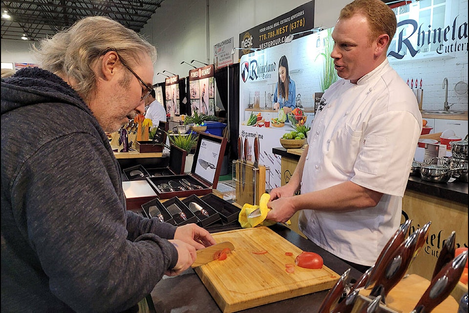 Michael Wadham (right) demonstrates a Miracle Chef knife for a customer at the Ridge Meadows Home Show on Saturday. (Neil Corbett/Maple Ridge News)