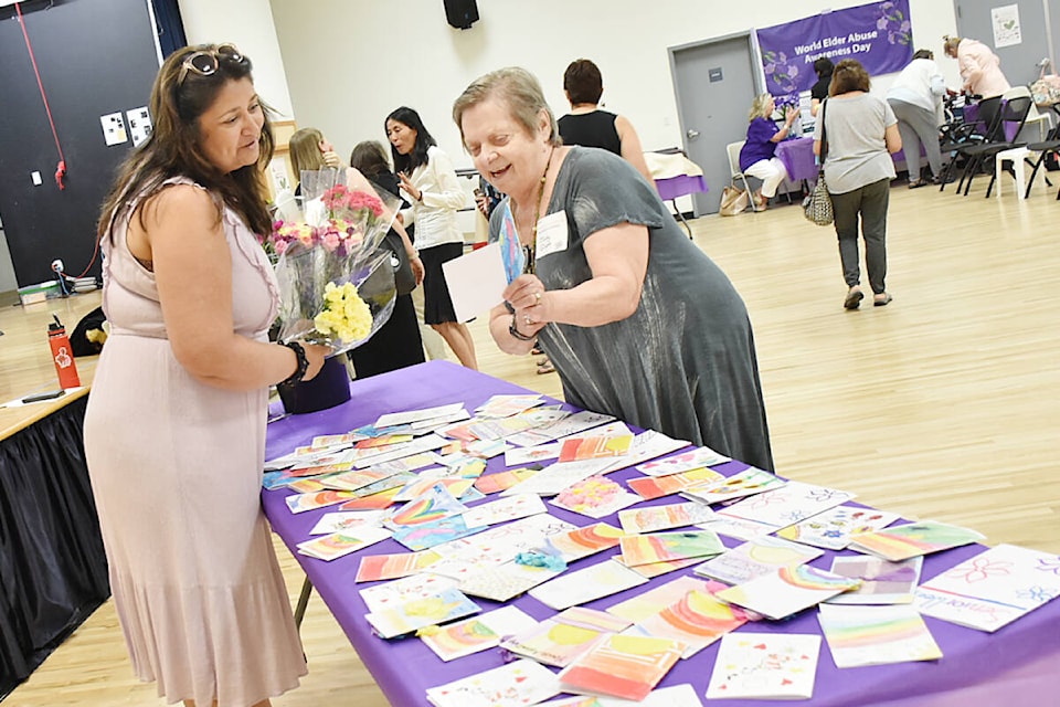 Maria Perretta, executive director of the Ridge Meadows Seniors Society, hands out carnations and cards made by students at St. Patrick’s Catholic School, to seniors for B.C. Seniors’ Week. (Colleen Flanagan/The News)