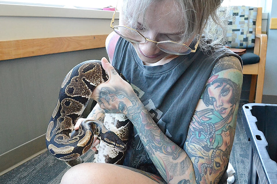 Christina Christie with Urban Safari Rescue Society holds a ball python named Charlie, before it was shown to children at the library. (Colleen Flanagan/The News)