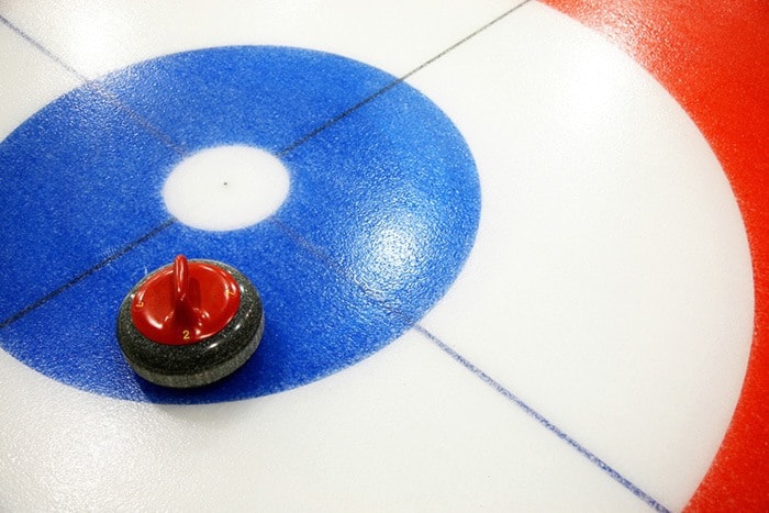 Curling stone on ice rink