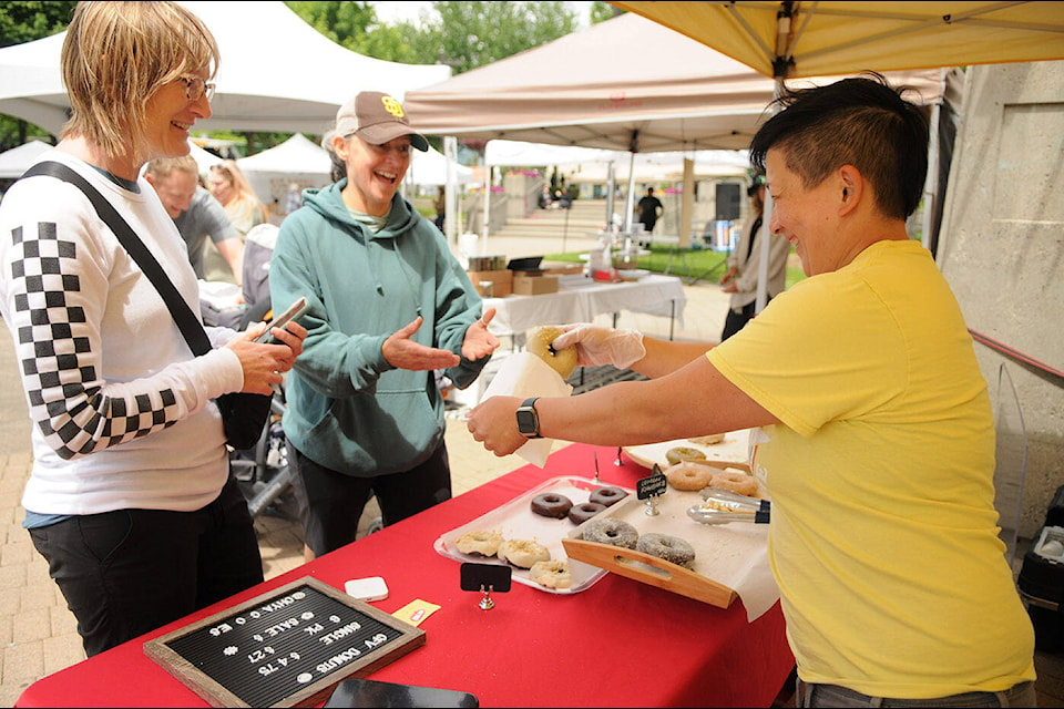 Cheryl Chang of Oh Yas Goodies (right) packages up a doughnut order at the inaugural Vegan Foodie Festival at Central Community Park in Chilliwack on Saturday, June 17, 2023. (Jenna Hauck/ Chilliwack Progress)
