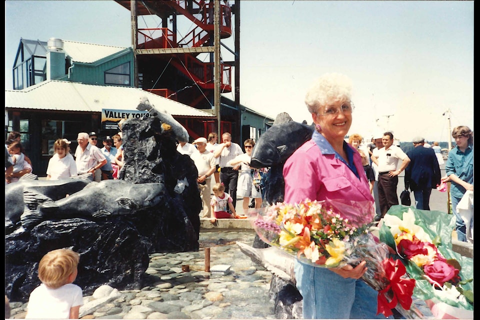 Babe Gunn receives a bouquet of flowers during the unveiling ceremony for ‘Our Rugged Returning Salmon,’ her commissioned sculpture in the fountain at Harbour Quay, May 23, 1992. (PHOTO COURTESY COMIS FAMILY)