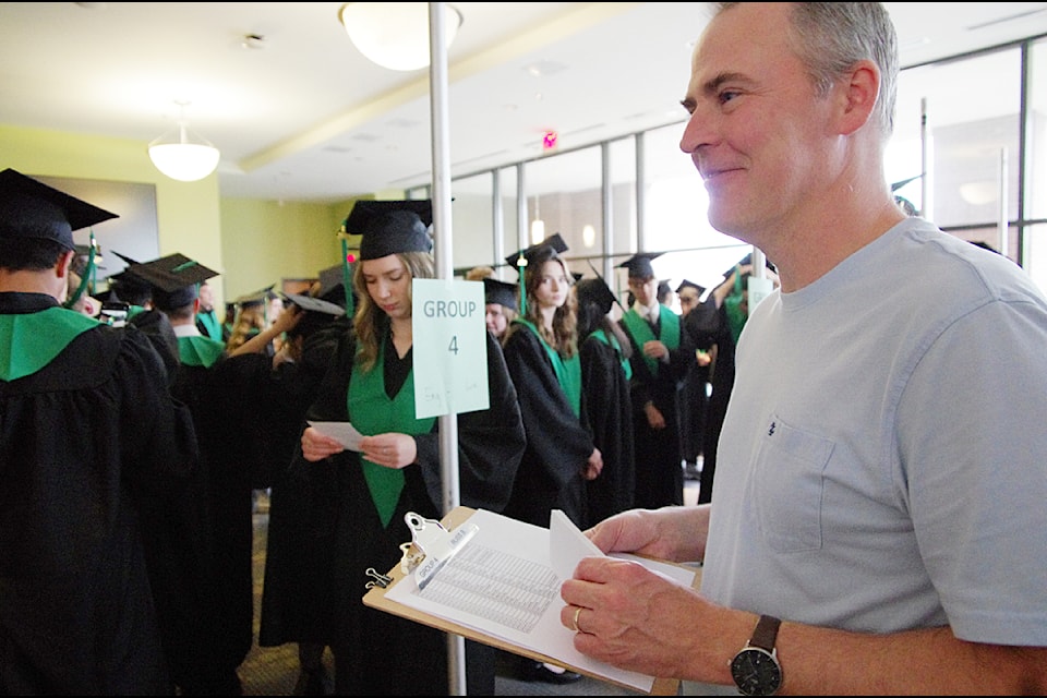 Teacher Russ Bueckert makes sure students are positioned alphabetically according to their surnames. 