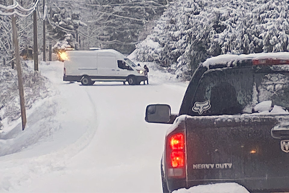 Passersby help spin a delivery van to face downhill after it lost traction on ice on Cedar Road south of Nanaimo on Monday, Feb. 3. 
(Laurie Hawthornthwaite photo)