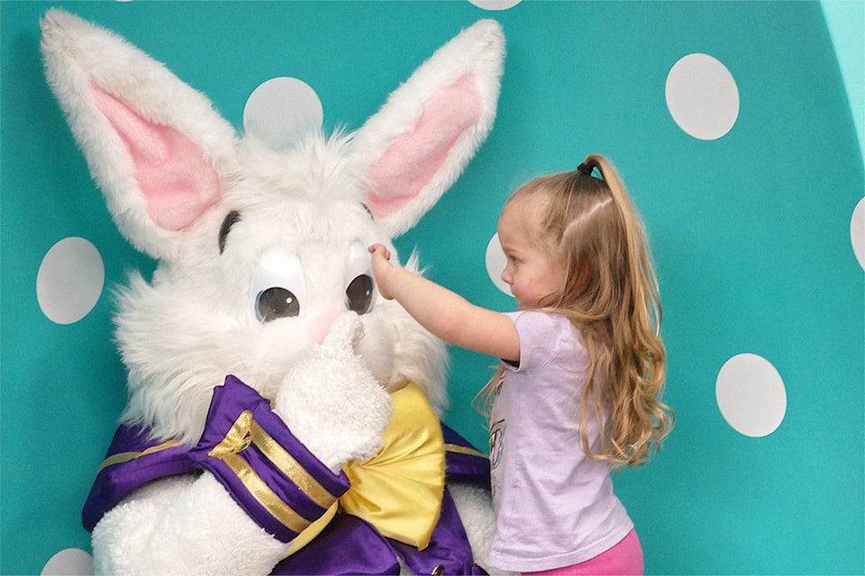 Nova Skapski, 3, checks out the Easter Bunny's large eyes and ears when they visited Friday, April 11. 
(Chris Bush/News Bulletin)