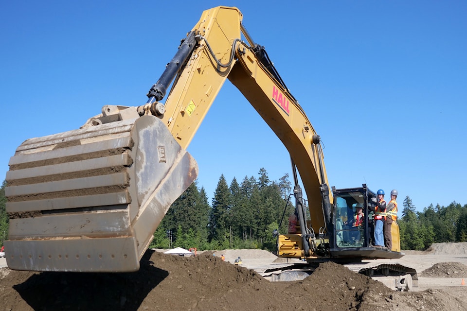 Grade 11 Nanaimo District Secondary School students McKenzie Kearns, left, and Piper Faux, are shown the basics of operating a large excavator before taking their turns at the controls at VIU's heavy equipment operators program training centre on Thursday, May 1. (Chris Bush/News Bulletin)
