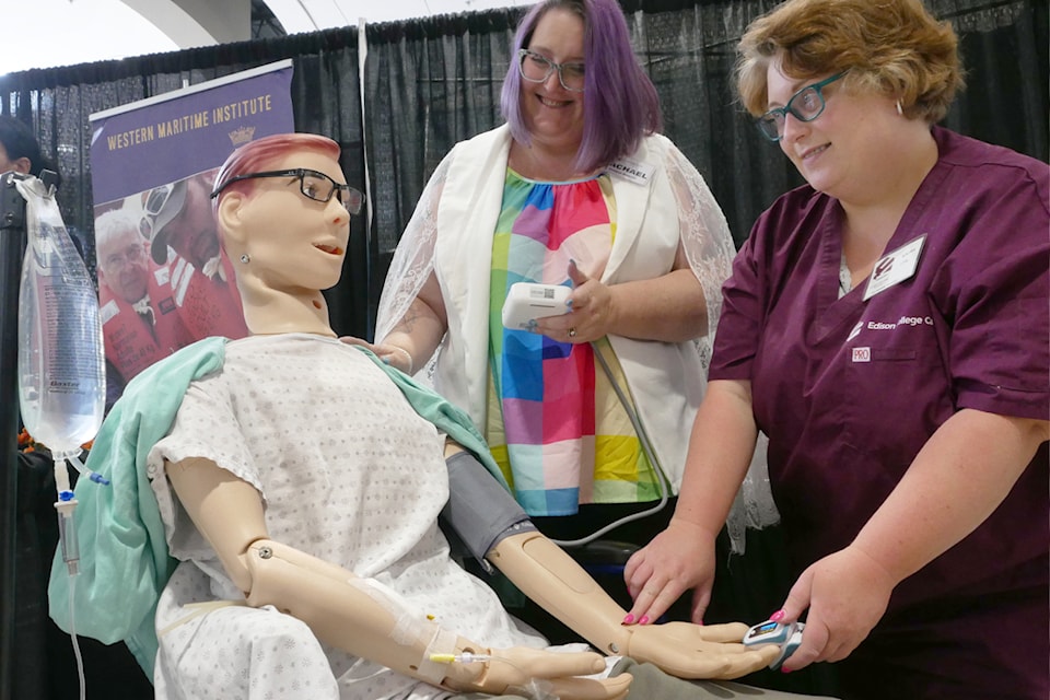 Gary the training mannequin gets a check on his overall well-being from Edison College Canada’s Rachel McPherson, director of the college’s Victoria campus and Laura Schulte, instructor and program coordinator, at the Nanaimo Career and Education Expo at Country Club Centre on Thursday, May 29. (Chris Bush/News Bulletin)