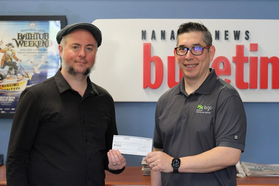 Graham Shonwise, Nanaimo News Bulletin circulation manager, presents a $2,000 cheque on behalf of the News Bulletin’s Coins for Kids fundraiser to Corey Sugiyama, interim executive director of BGC Central Vancouver Island. (News Bulletin photo)