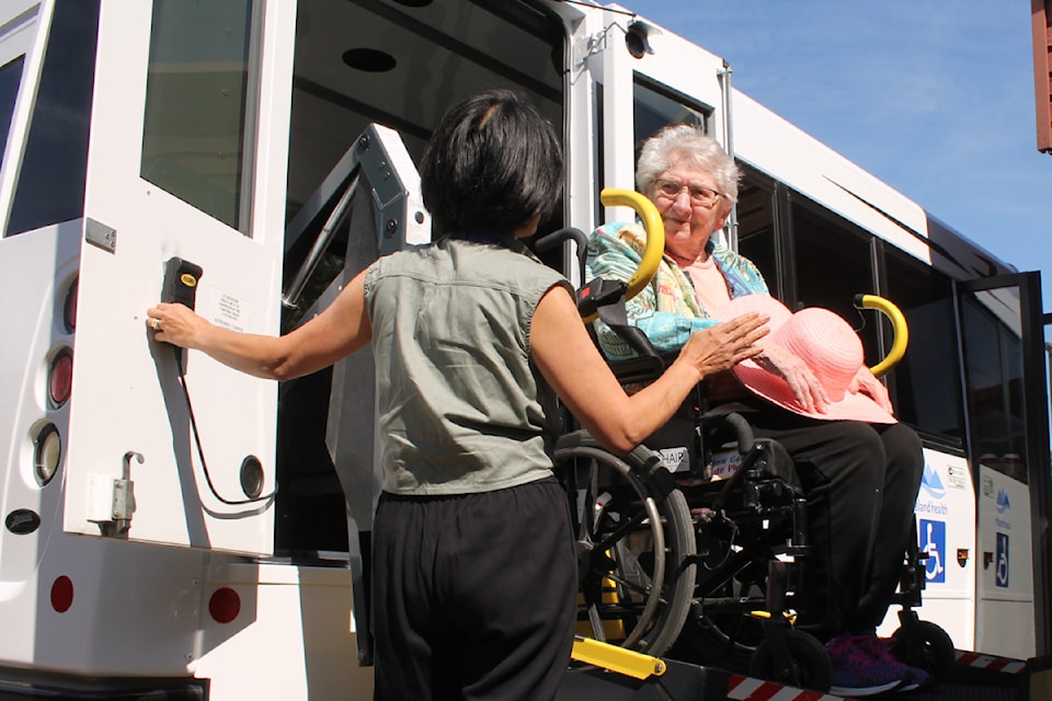 Analiza Maguire, Dufferin activity assistant, helps Shirley Foucher into Dufferin Place's new bus. (Jessica Durling/ News Bulletin)