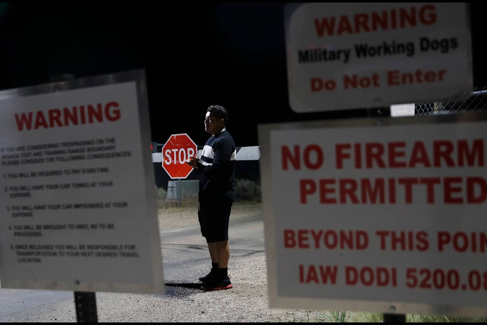 A man stands at an entrance to the Nevada Test and Training Range near Area 51 Friday, Sept. 20, 2019, near Rachel, Nev. People gathered at the gate inspired by the “Storm Area 51” internet hoax. (AP Photo/John Locher)