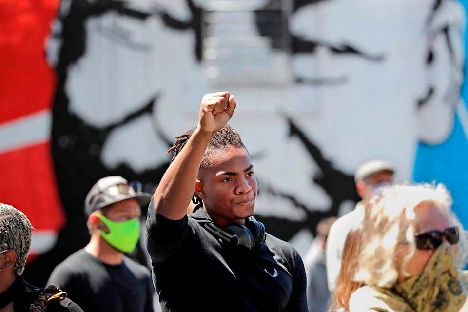 Hanz Jouissance holds up a fist at the conclusion of a prayer vigil at the First AME church Monday, June 1, 2020, in Seattle, following protests over the weekend over the death of George Floyd, a black man who was in police custody in Minneapolis. (AP Photo/Elaine Thompson)