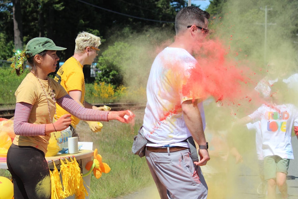 Ian Orth spins as Emmily Wildman, from WildPlay Nanaimo, tosses coloured powder at the BGC Central Vancouver Island Colours for Kids fundraiser in Nanaimo May 27. (Karl Yu/News Bulletin)