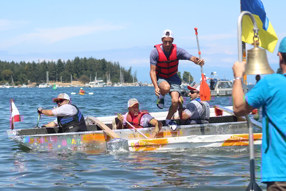 Greg Litvinov, Roman Soldatenko, Michael Mrachenko and Pavlo Fedorov of the Aarsen Gutters team reach the finish-line bell to win the grand final at this year's Silly Boat Regatta on Sunday, July 20, at Maffeo Sutton Park. (Greg Sakaki/News Bulletin)