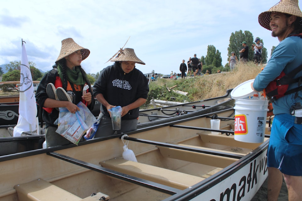 Dude Lenon, left, Harvey Barnes and Kaimemeux Blaney clean out their canoe. (Karl Yu/News Bulletin)