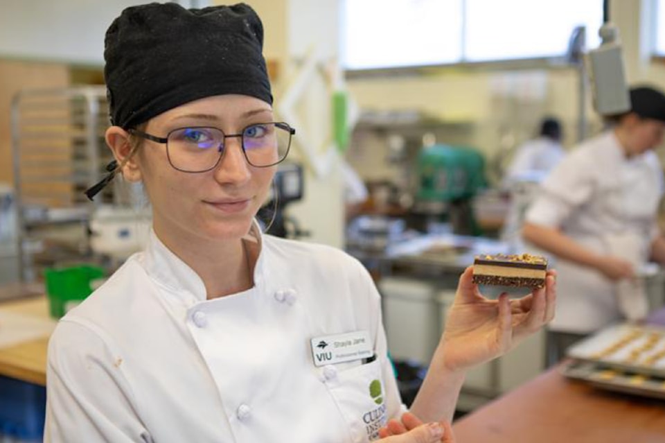 viu-baking-and-pastry-arts-management-diploma-program-student-shayla-jane-heslin-holds-up-a-nanaimo-bar