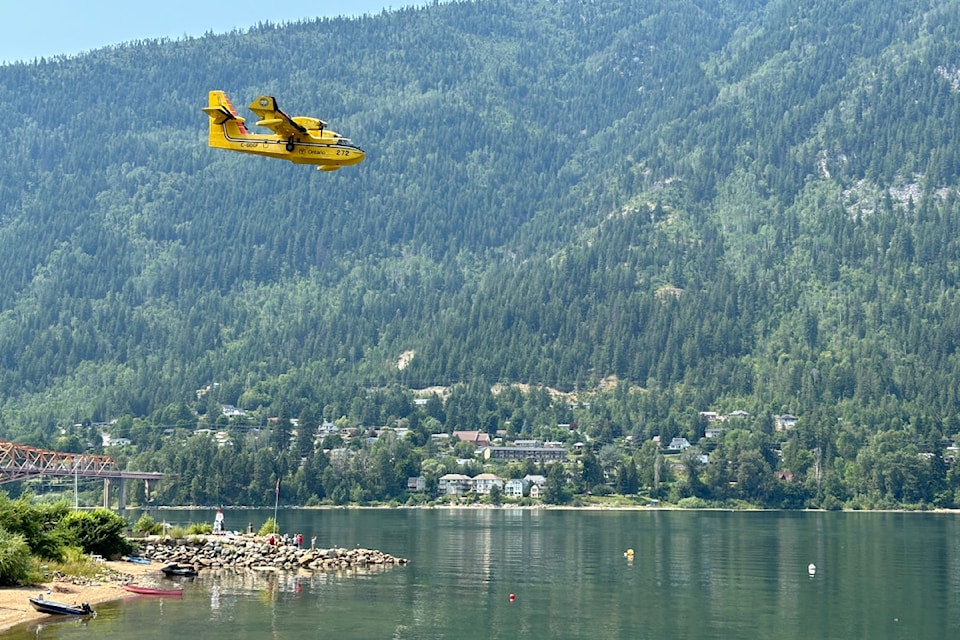 A water bomber drops low in Nelson to collect from Kootenay Lake on July 18.