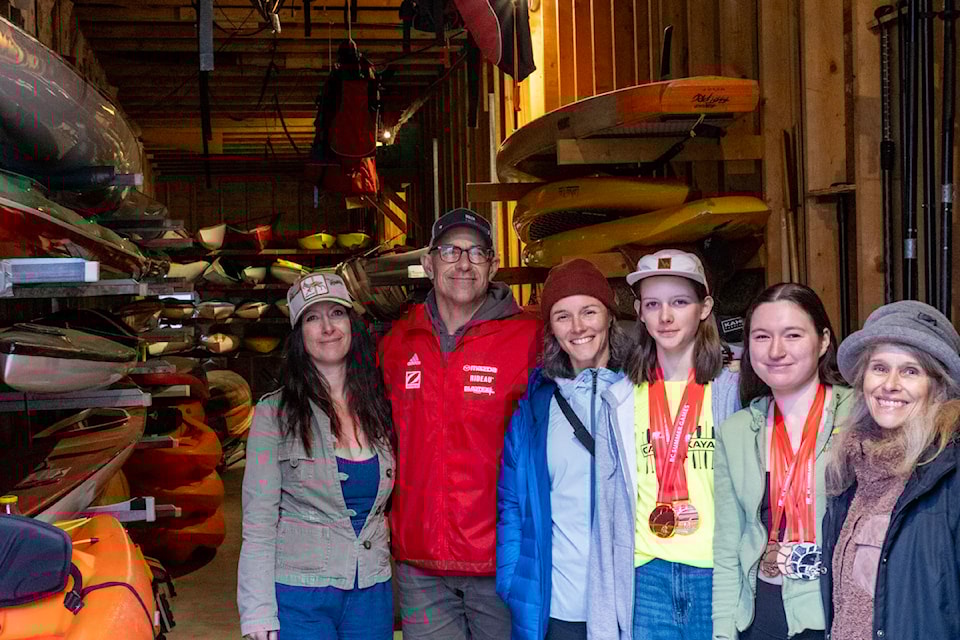Members of the Nelson Paddling Club. L-R: Stephanie Collinson, past president Jason Rusu, Daphne Powell, past BC Games medal winners Lila Beckman and Maya Collinson, and president Daija Currie, with the club's 51 boats at the Lakeside Park boathouse.