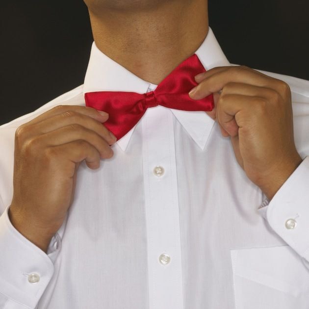 Man adjusting bow tie with hands