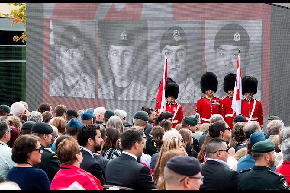 Faces of the fallen are shown on a screen during the rededication ceremony of the Kandahar cenotaph at National Defence Headquarters in Ottawa on Saturday, Aug. 17, 2019. THE CANADIAN PRESS/Justin Tang