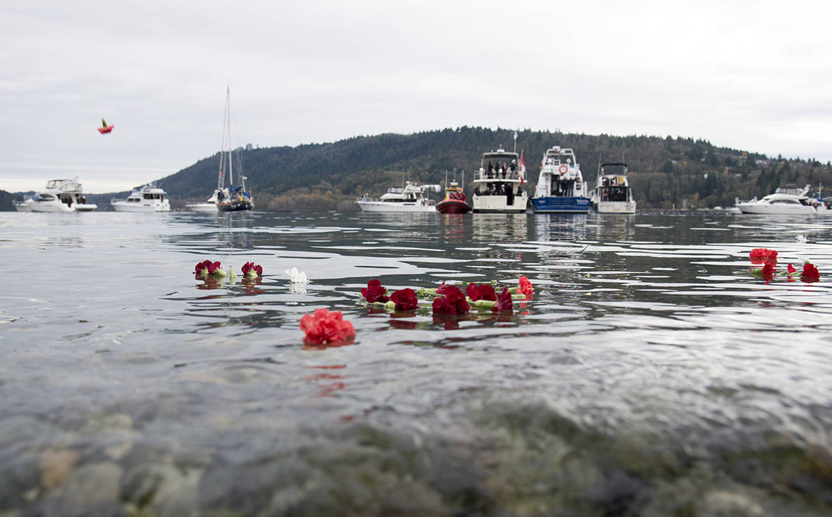 Flowers are seen floating in the sea during a maritime Remembrance Day ceremony in Burrard Inlet in North Vancouver, B.C., Monday, November, 11, 2019. THE CANADIAN PRESS/Jonathan Hayward