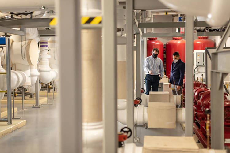 Glen McIntyre, Thermal Energy Manager, UBCO, and Juan Rincon, Key Account Manager, FortisBC, tour the utilities area of the Commons building at the UBCO campus.