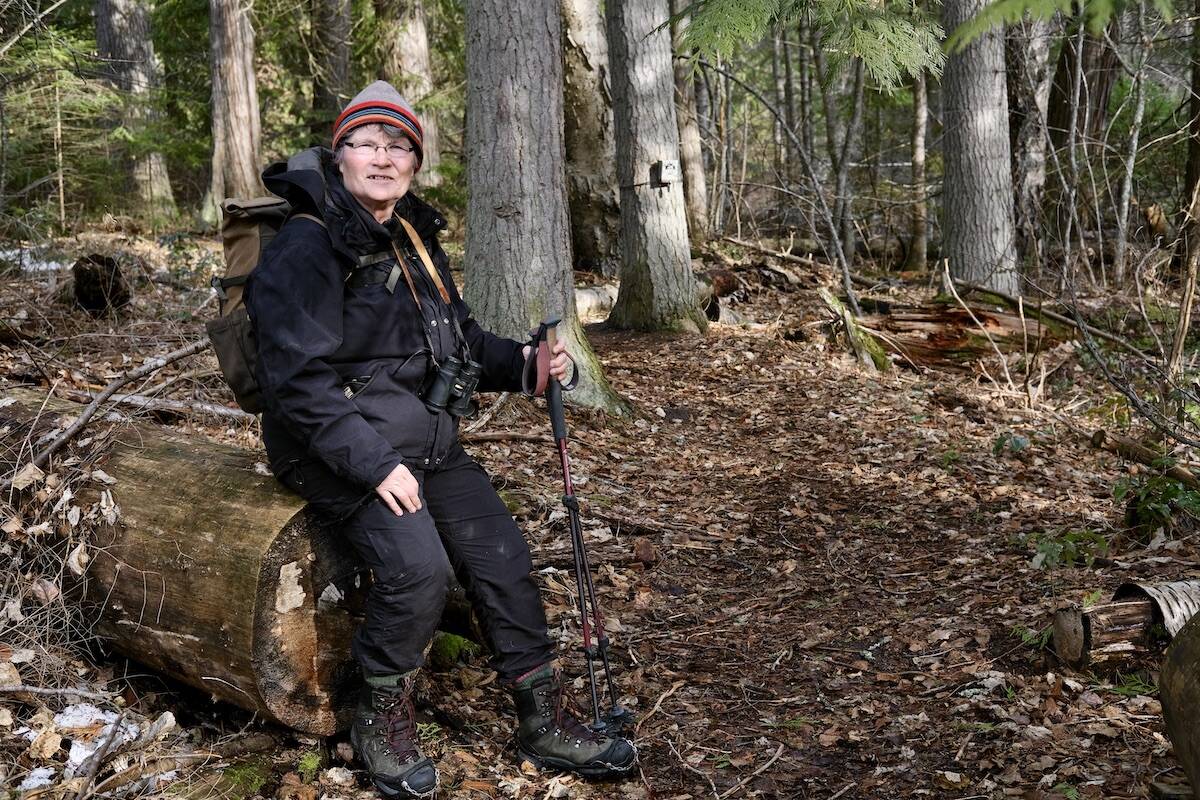 Wildlife biologist Joanne Siderius at Kokanee Creek Provincial Park. A trail camera can be seen attached to a tree in the background. Photo: Bill Metcalfe