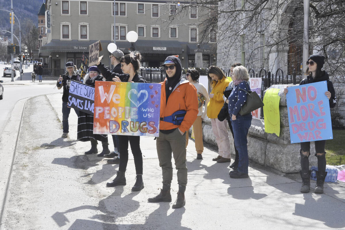 A group holds signs up outside Nelson City Hall as traffic drives by Friday. The Nelson area had a record 11 toxic drug deaths in 2022. Photo: Tyler Harper