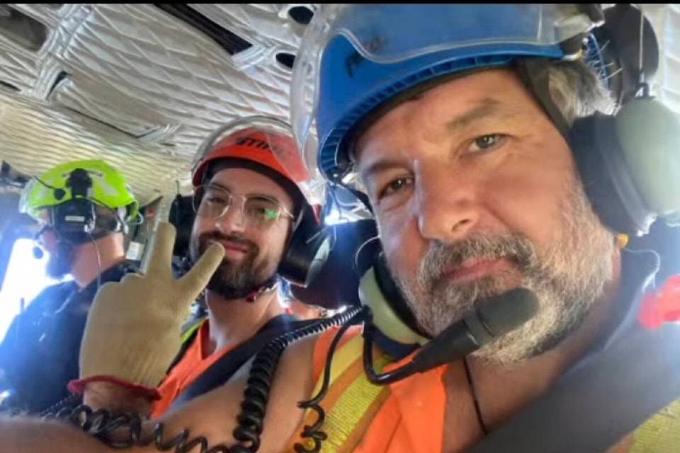 Paraglider Jack Pincus, centre, from the Comox Valley and rescuers Dave Potter from Totem Tree Service, right, and a member of Alberni Valley Rescue Society are flown away from Mount Irwin by Ascent Helicopters after Pincus was rescued from the top of a 35-metre Douglas fir. (PHOTO COURTESY DAVE POTTER)