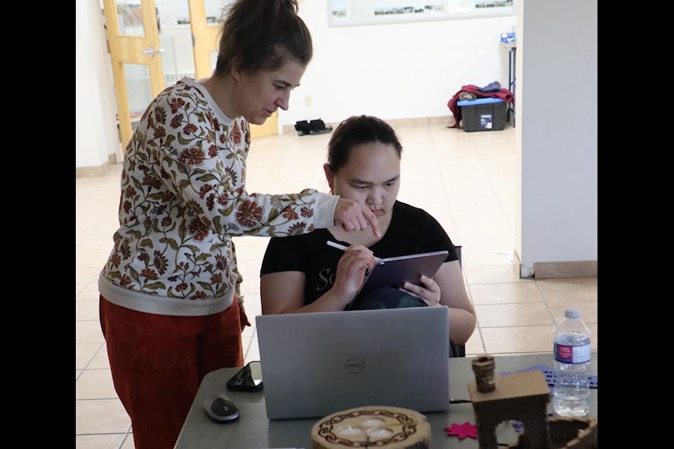 From left, Jazmine Gardner gives Dakota Whitbread some pointers on her digital design at a makerspace workshop in Aklavik. Photo courtesy of Jennifer Rafferty