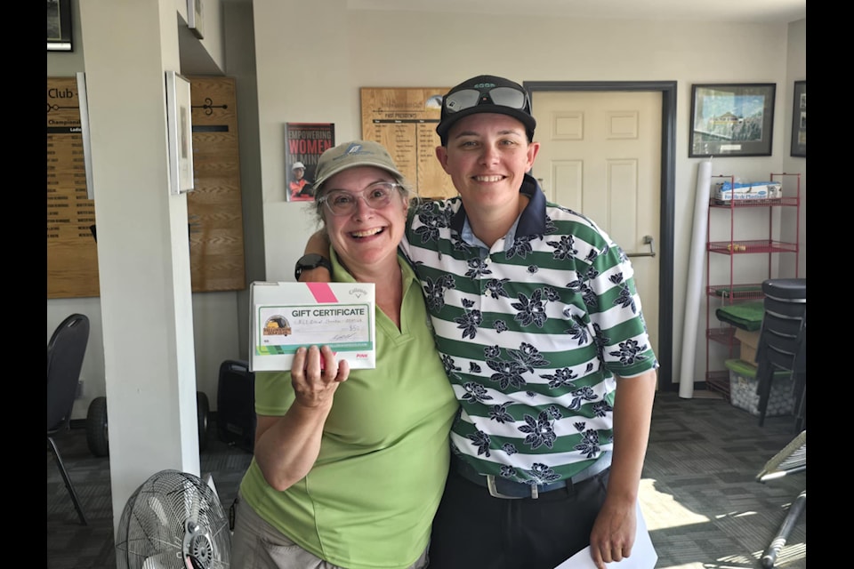 Kylie Frederick, director of golf operations at the Yellowknife Golf Club, presents Renee Jones with her prize for having the best low net score in the Ladies F*ck Cancer golf tournament on July 28.