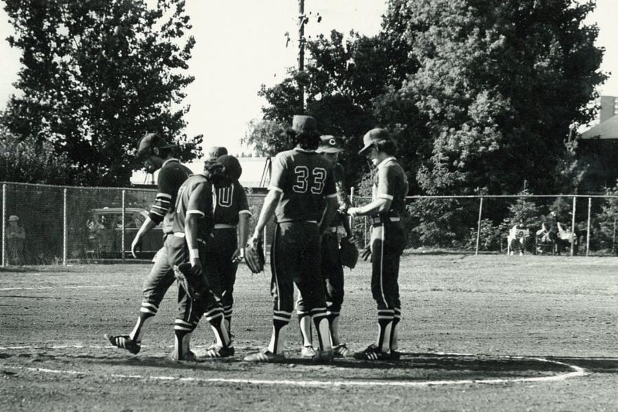The Yellowknife Junior Merchants, wearing their borrowed uniforms, chat in the pitchers' circle in between plays. Photo courtesy of Sport North