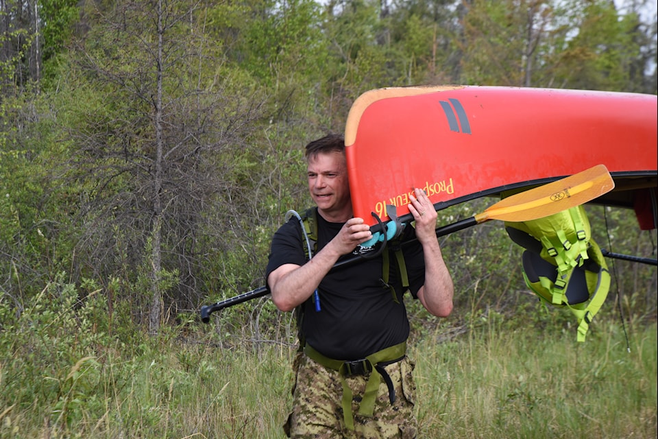 Navy Captain Doug Layton portages a canoe. Photo courtesy of Maj. Alexandre Muñoz