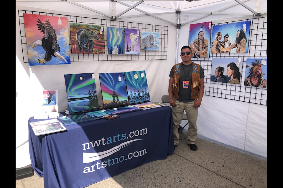 Yellowknife painter Darrell Chocolate stands at this booth at the 2024 Toronto Outdoor Art Fair. Many people were impressed by the detail of his work, he said. Photo courtesy of NWT Arts