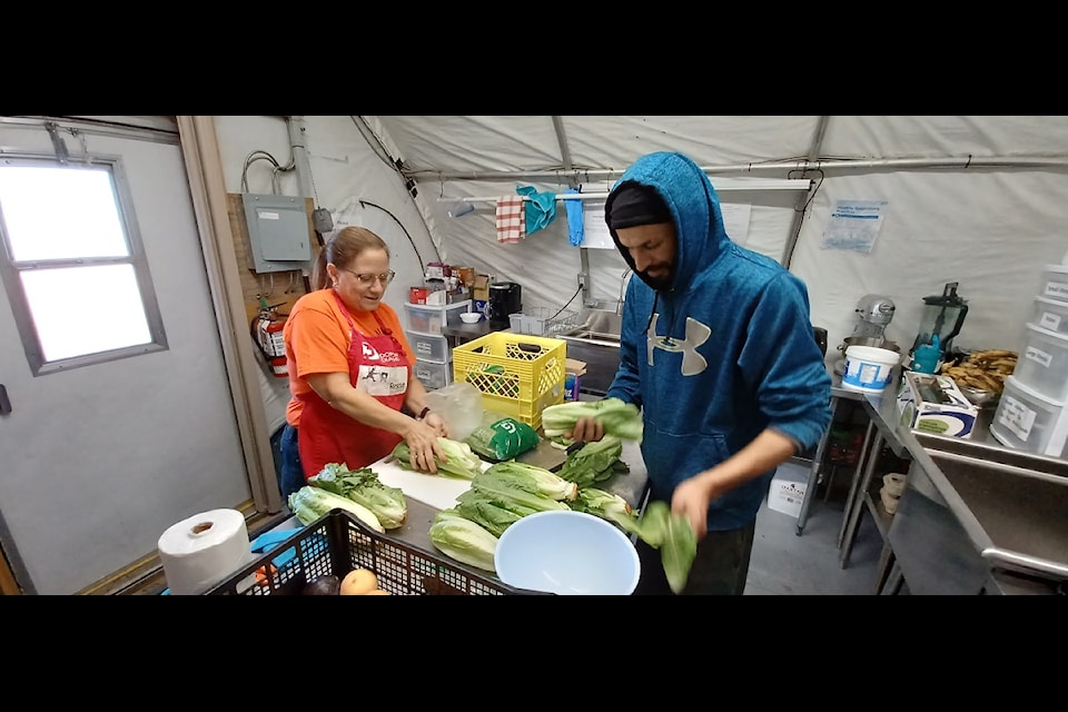 Cathie Bolstad, left, and Aziz Ahmed work on salvaging lettuce at Food Rescue's sorting location in Yellowknife. Columnist Nancy Vail suggests helping out with Food Rescue as a way to give in a different way this Christmas season. NNSL file photo