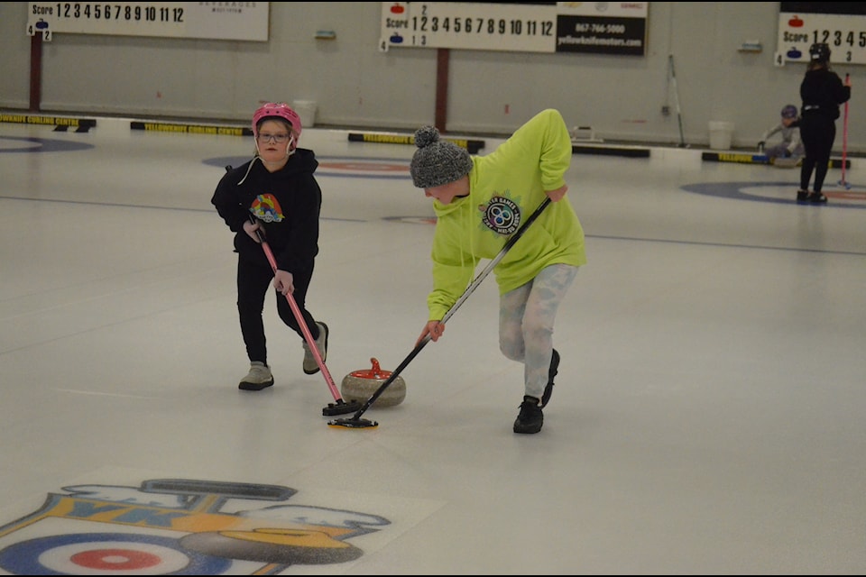 Maren Webb, left, and Shelby Coakwell put brooms to rock during action in the Rock The Rings youth bonspiel in Yellowknife on Sunday. James McCarthy/NNSL photo
