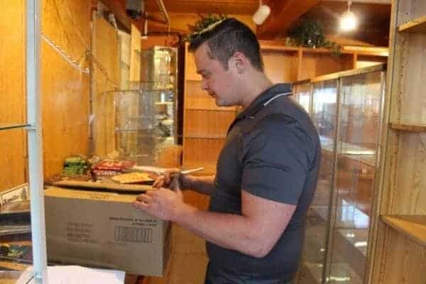 Assistant manager Tyler Dempsey packs up a box of books from the near-bare shelves left at the Northern Frontier Visitors Centre on Wednesday, May 24. Kirsten Fenn/NNSL photo 