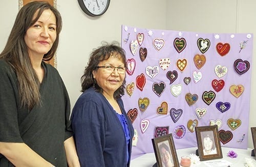 Temporary victim service worker Michele Larocque, left, and victim service worker Marie Speakman, stand in front of the Beaded Heart Project, an art exhibit dedicated to indigenous women who have gone missing or been murdered, on May 19. The victim service workers at the Native Women's Association of the NWT also offers more immediate assistance to victims of crime, including emotional and material support to sexual assault survivors. Emelie Peacock/NNSL Photo