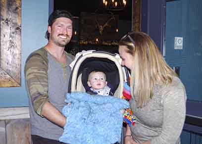 Fletcher , left, and Miranda Stevens stand in the entrance to The Woodyard Brewhouse & Eatery with their son Casey on May 26. A liquor licensing board designation prevents the two entrepreneurs from bringing Casey into their restaurant as it is a liquor primary establishment. However, Casey is allowed to be in the brewery surrounded by large steel vats of beer. This is just one example of bureaucratic red tape the couple has faced in opening the territory's only craft brewery. Emelie Peacock/NNSL Photo 