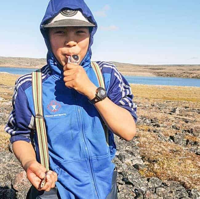 Tuugaalik High School Grade 9 student Pakka Arnatsiaq enjoys a juicy caribou eyeball during his class's land trip in Naujaat on Sept. 6, 2018. photo courtesy of Julia MacPherson