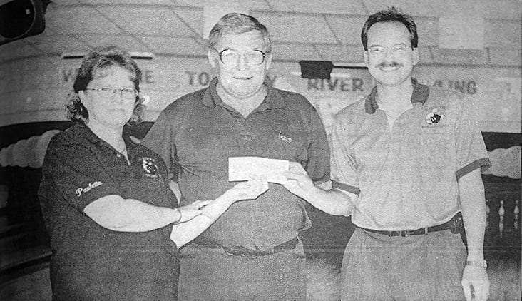Pictured are Paulette West, left, vice president of the Hay River 5-Pin Bowler's Association and Brian Lefebvre, owner of Hay River Bowling Lanes, presenting Hamilton his reward. ϳԹ file photo.