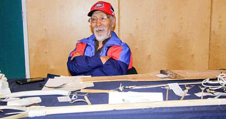 Elder Honore Aglukka of Naujaat sits behind his collection of traditional Inuit tools at the ninth annual Kivalliq Trade Show's Art Festival at Simon Alaittuq School in Rankin Inlet on Sept. 25, 2018. Darrell Greer/ϳԹ photo