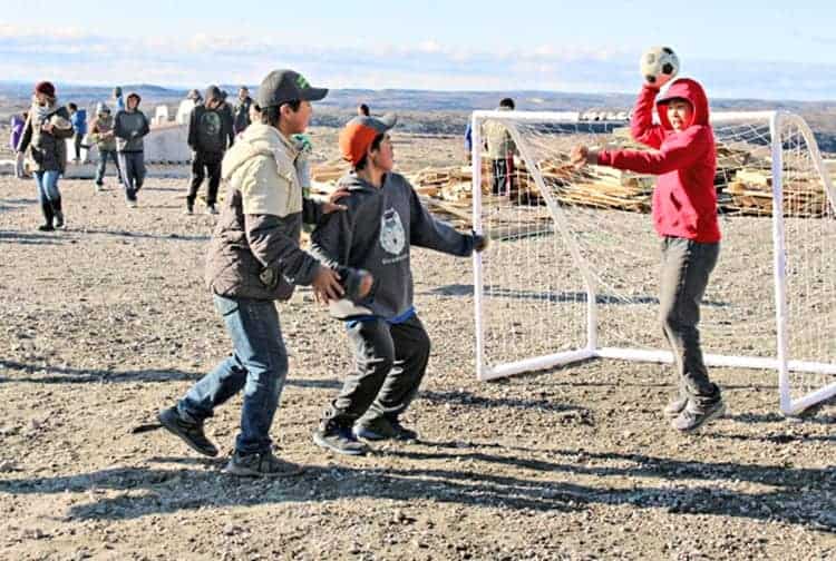 Goalie Pakka Arnatsiaq is ready to try and pass the ball as Curtis Siusangnark, centre, and Quentin Tuktudjuk put the pressure on in front of his goal during Embrace Life activities at Tuugaalik High School in Naujaat on Sept. 28, 2018. Photo courtesy Julia MacPherson