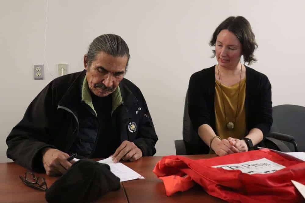 JC Catholique, left and Erin Suliak sign the donation agreement that allows 200,000 Native press photos to be digitally archived. Dylan Short/NNSL photo