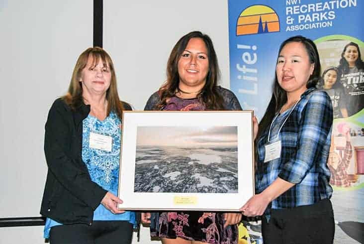 Beth Hudson, centre, receives the Innovation Award from Caren Burke, left, and Mary Gordon, both board members of the NWT Recreation and Parks Association, during the association's awards banquet in Yellowknife on Oct. 24. James McCarthy/NNSL photo.