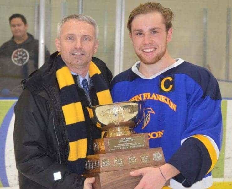 Dean MacInnis, principal of Sir John Franklin High School, presents Jack Panayi, captain of Sir John Franklin's boys team, with the championship trophy after the Falcons beat St. Pat's in the Wade Hamer Challenge Cup boys game in November 2017. NNSL file photo